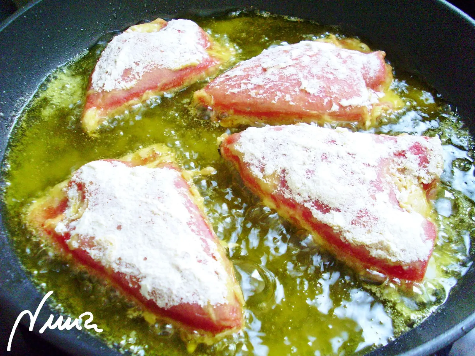 Pimientos del piquillo rellenos de bacalao, paso 3: Pasar los pimientos rellenos por harina y freír en un poco de aceite, dándoles la vuelta…