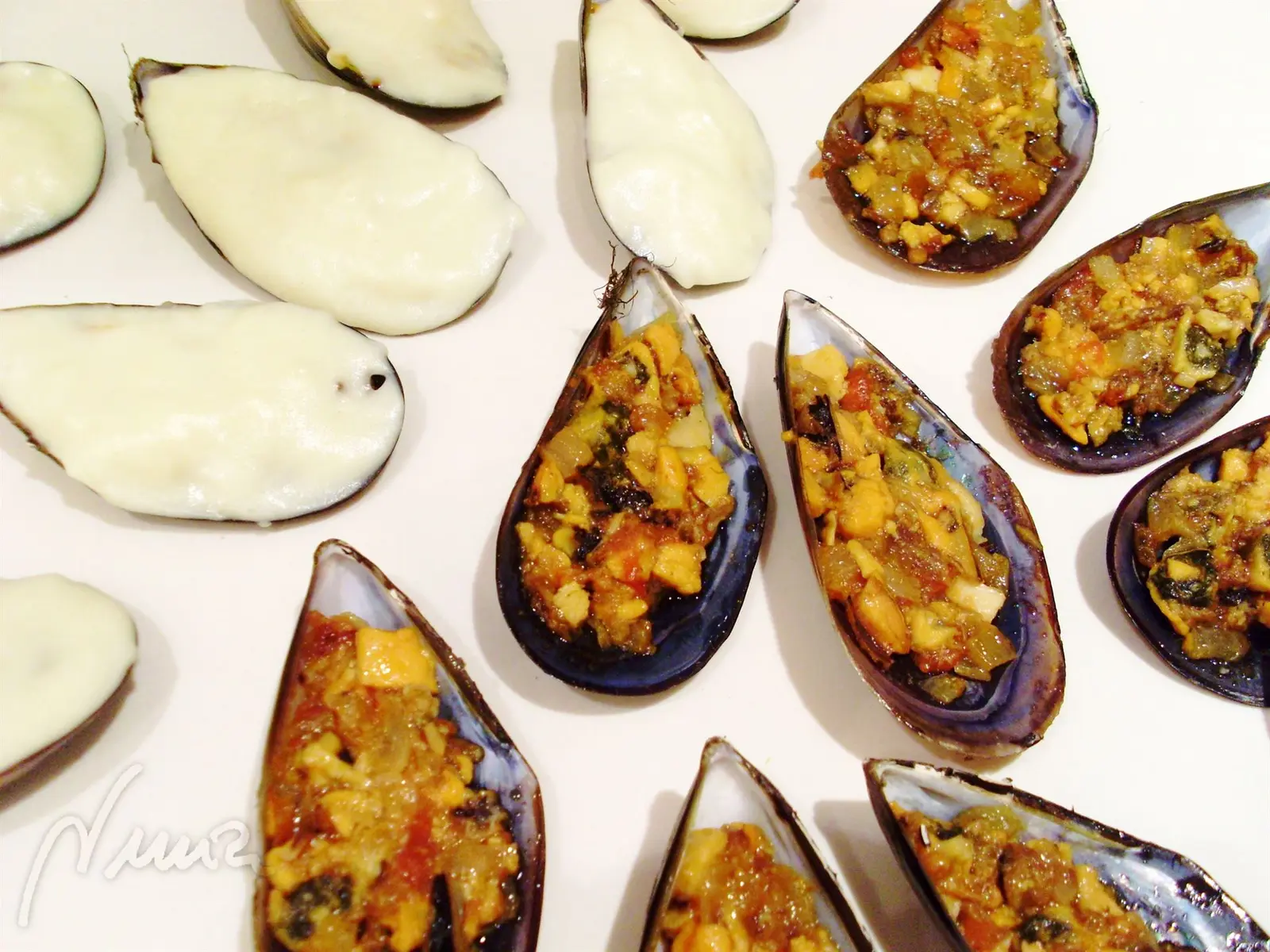 Monterías, paso 9: Cubrir con bechamel el relleno de cada concha enrasando y tapando por completo el…