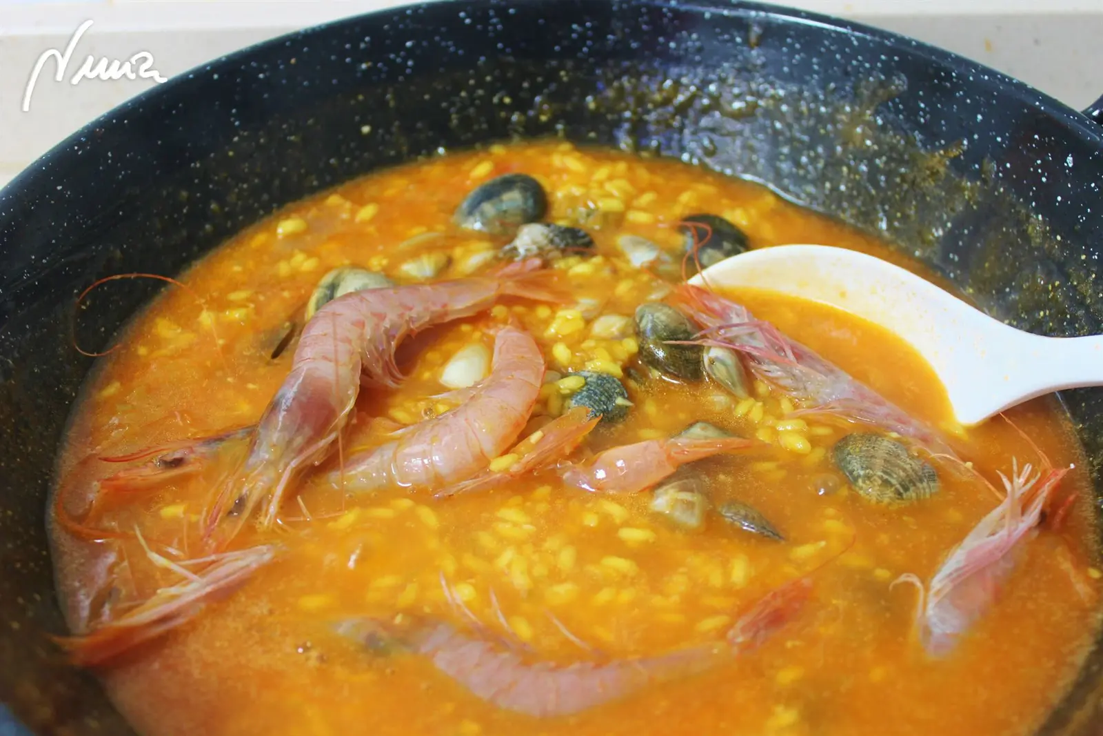 Arroz caldoso con marisco, paso 11: Cuando hayan pasado los 10 minutos exactos, escurrir el marisco y echarlo en cacerola: