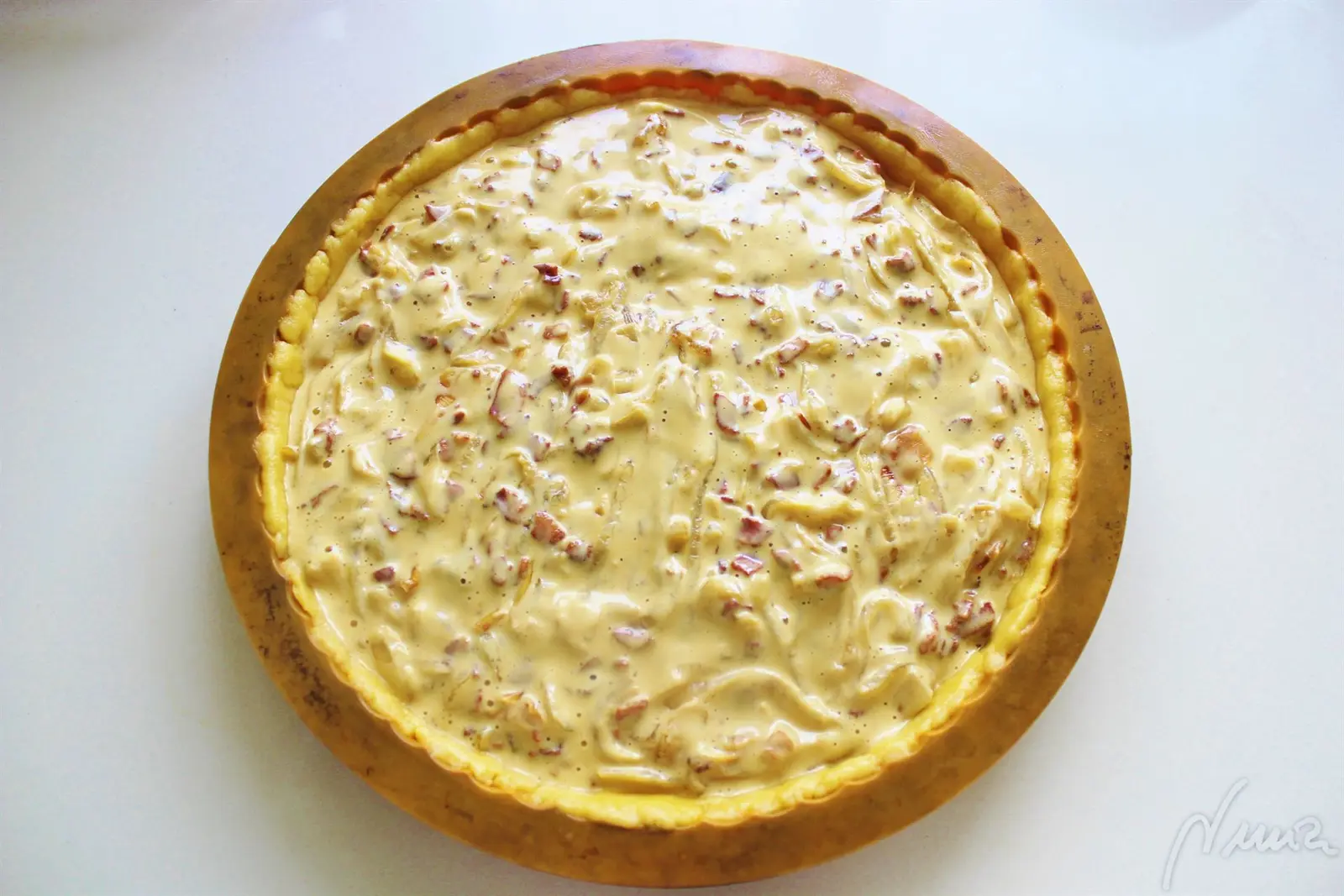 Tarta de cebolla, paso 9: Echar la mezcla de huevo y cebolla sobre la masa del molde, distribuyendo bien la…