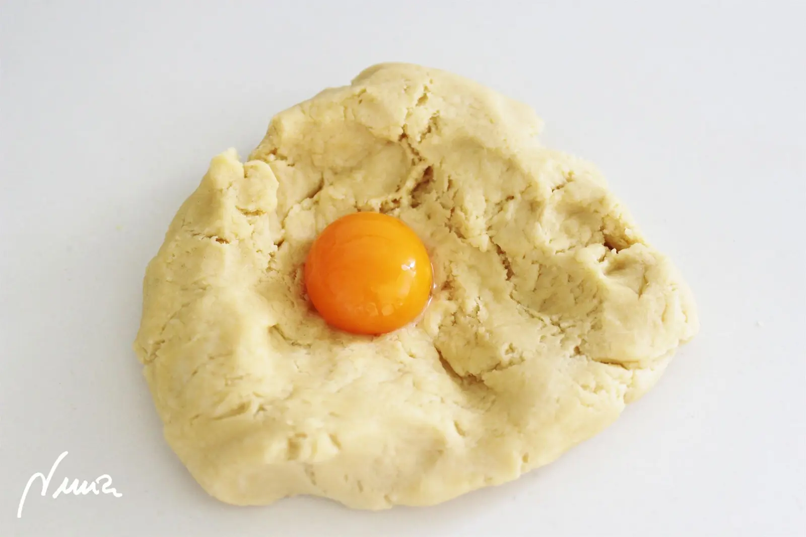 Pastel de manzana – paso a paso, paso 4: Volver a hacer un hueco en medio de la masa y añadir la yema de huevo.