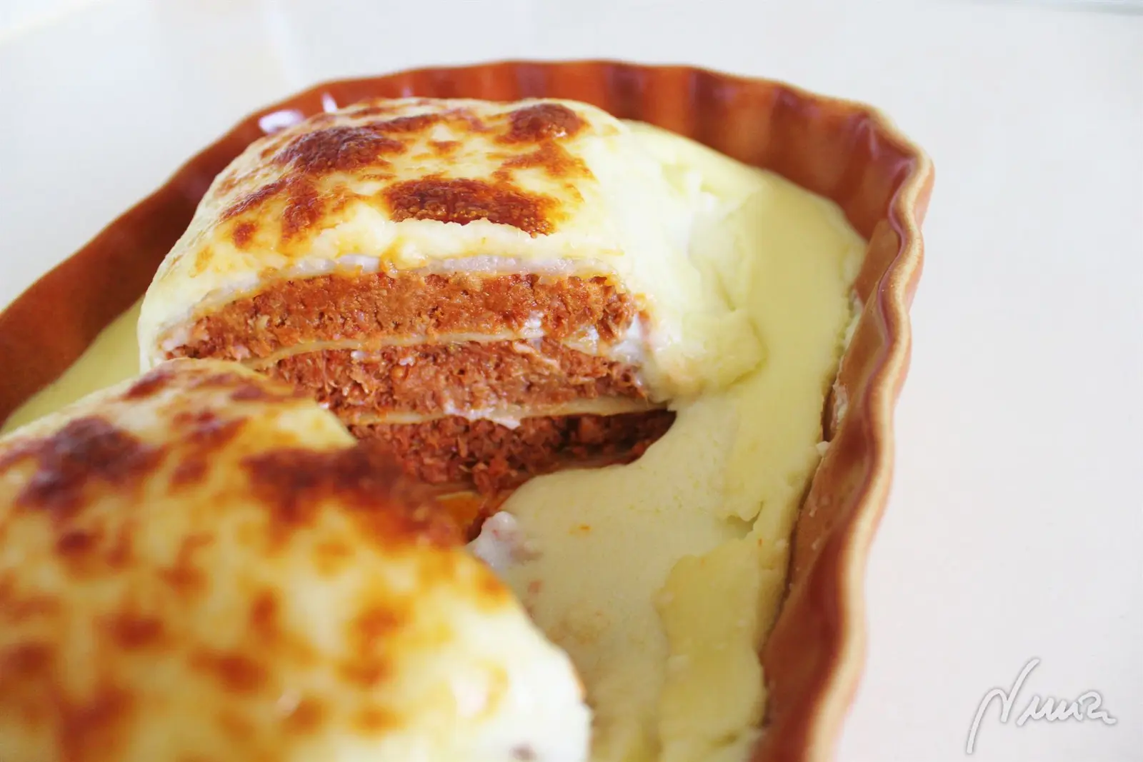 Lasaña de carne guisada, paso 11: Meter en el horno a fuego fuerte unos minutos, luego poner el gratinador hasta que la…