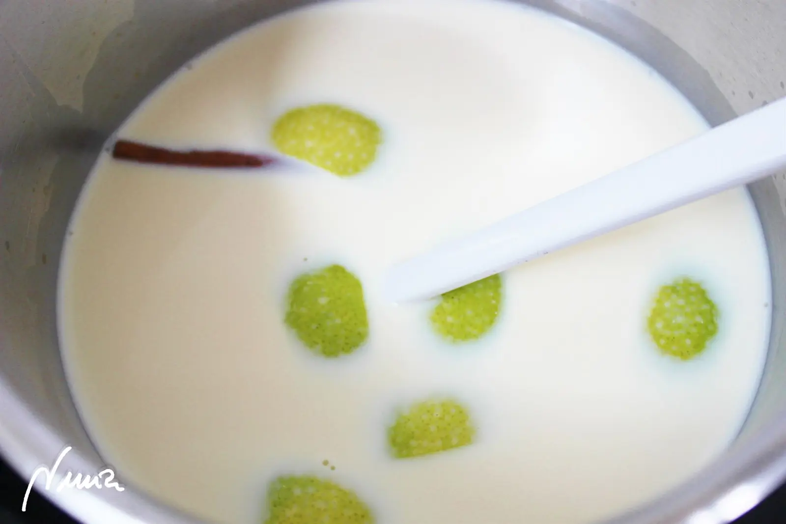 Crema catalana, paso 2: En una cazuela con asas y a fuego medio calentar la crema de leche y la leche, la piel…