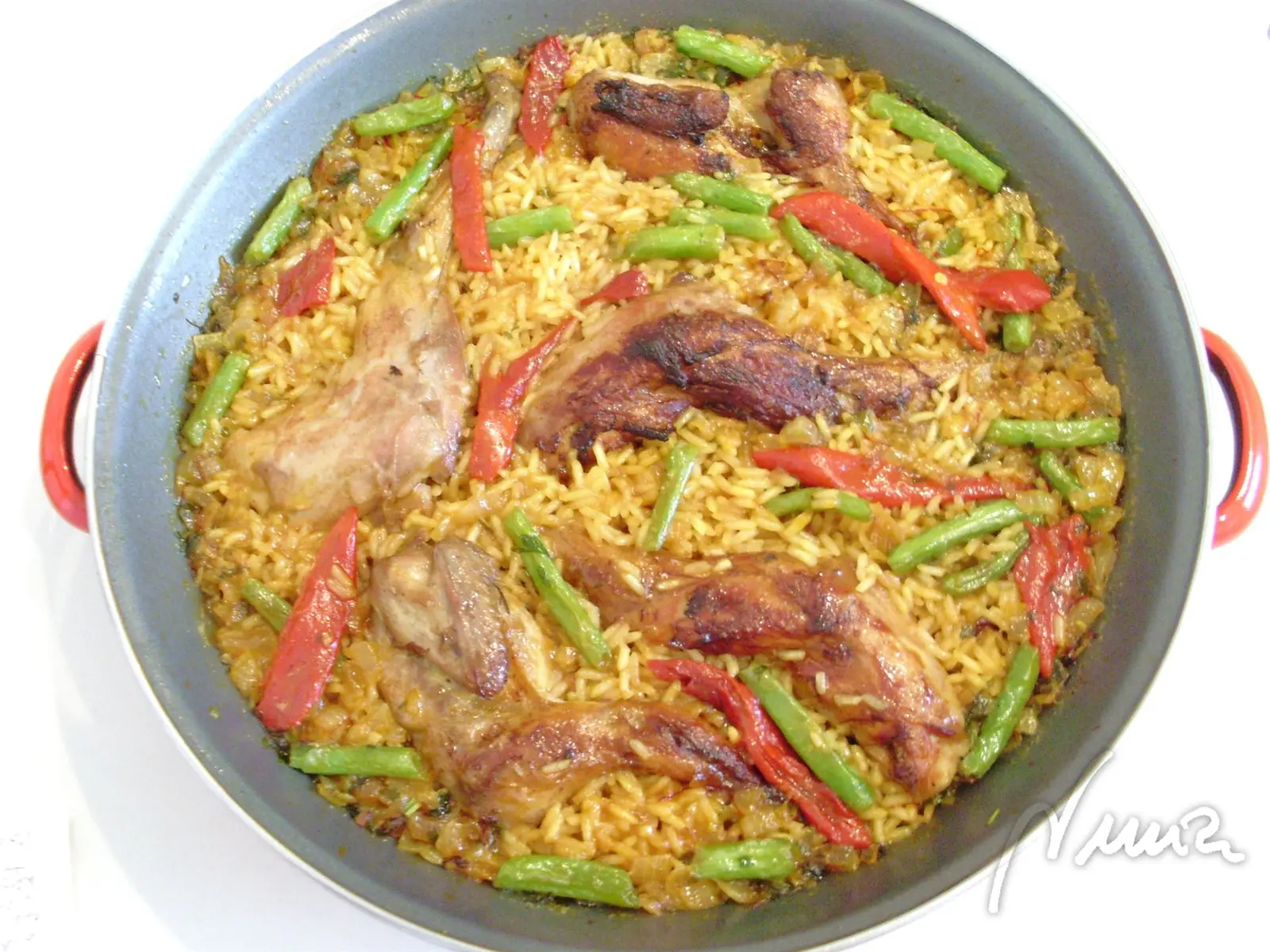 Paella de caza y verduras, paso 11: Añadir las carnes por encima y el pimiento en tiras y las judías verdes.