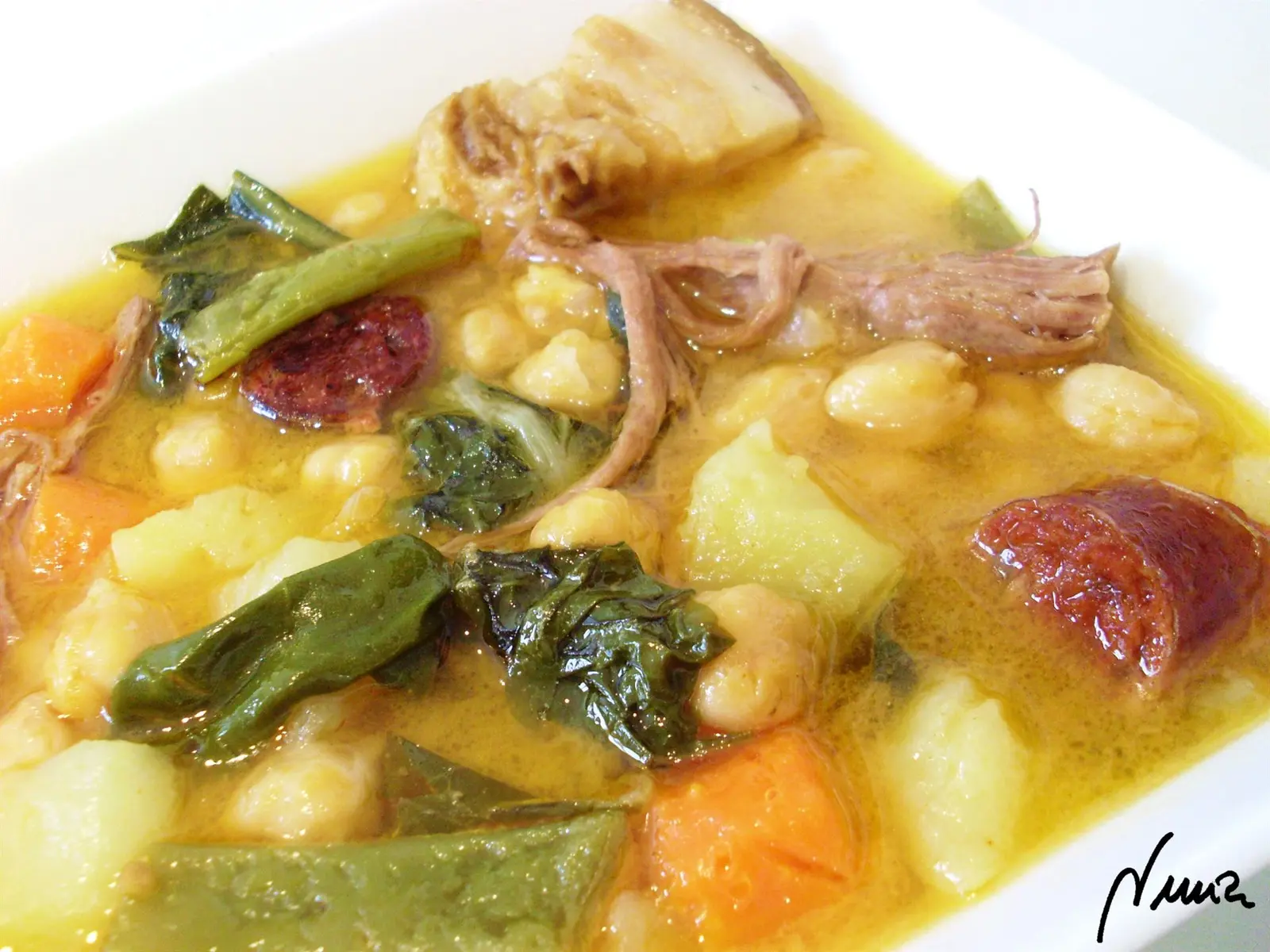 Cocido andaluz, paso 4: Servir el cocido de la olla en cada plato y luego añadir la patata troceada en daditos…