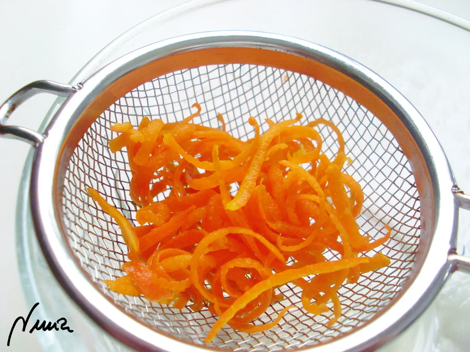 Confit de muslitos de pato mandarín-a, paso 11: Con un colador escurrir las virutas de mandarina: