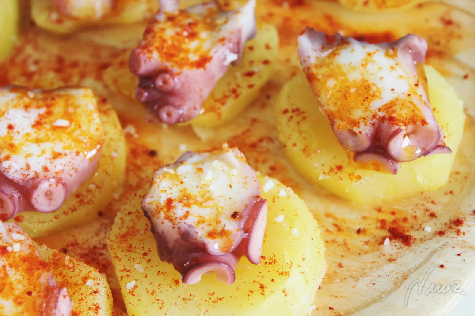 Pulpo a la gallega o a feira con cachelos, paso 16: Echar un chorrito de aceite de oliva por encima de toda la fuente de pulpo.
