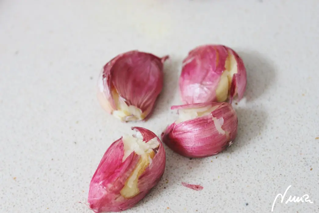 Aceitunas verdes aliñadas, paso 4: Dar un golpe a los 3-4 dientes de ajo con piel, para que se abran un poco, sin…
