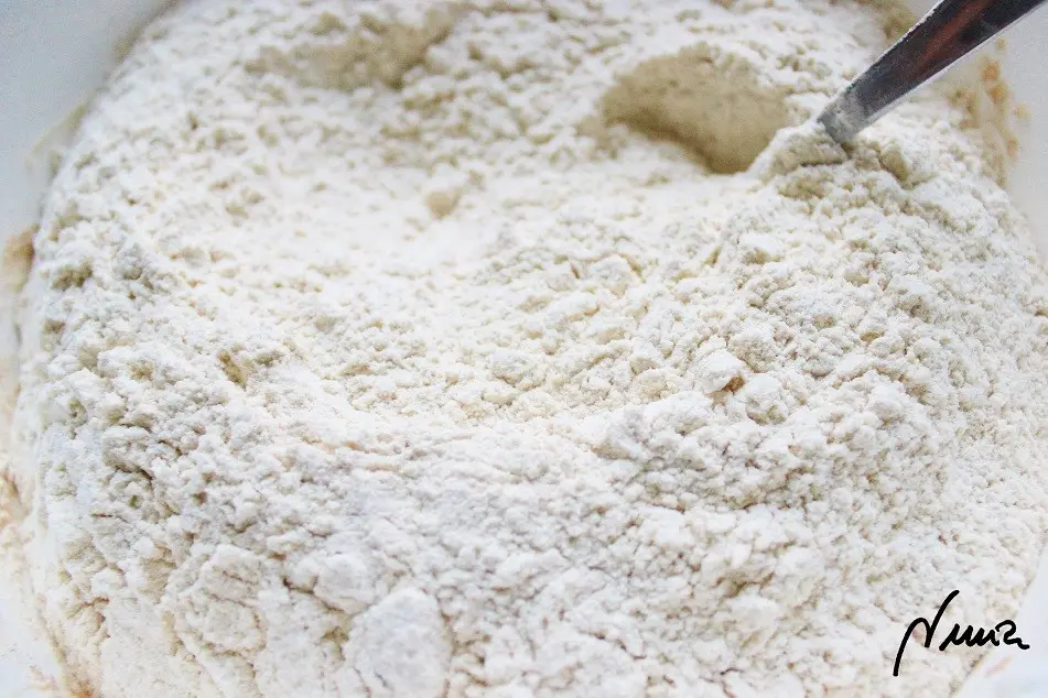 Polvorones del Espíritu Santo (de almendra), paso 13: 13 - Con el colador tamizar el kilo de harina directamente sobre la masa anterior…