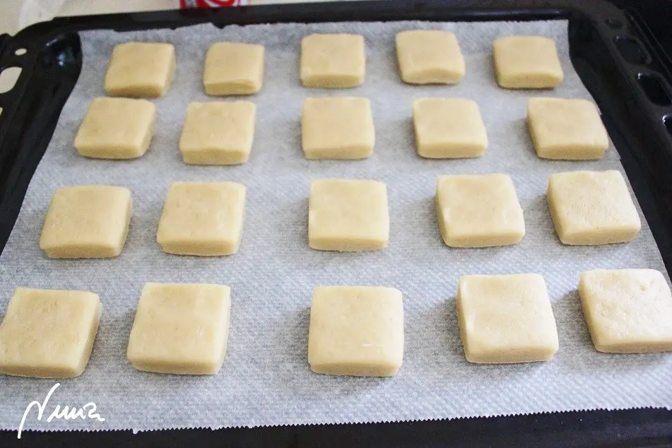 Hojaldrinas o nevaditos, paso 10: En bandeja de horno con otro papel vegetal colocar las porciones de masa con suficiente…
