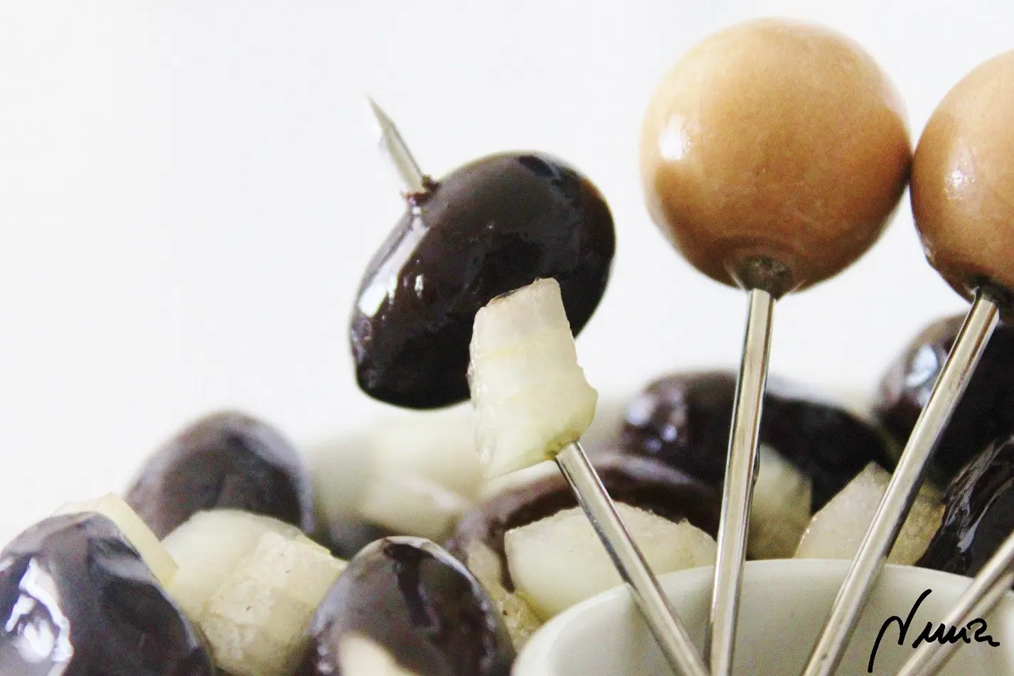 Aceitunas negras aliñadas, paso 3: Añadir el aceite y cebolla picada a las aceitunas y remover bien.