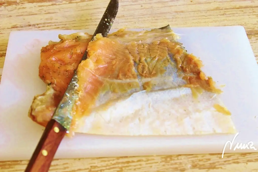 Salmón marinado, paso 12: Colocarlo sobre tabla y cortar en finas láminas con un cuchillo largo y muy afilado…