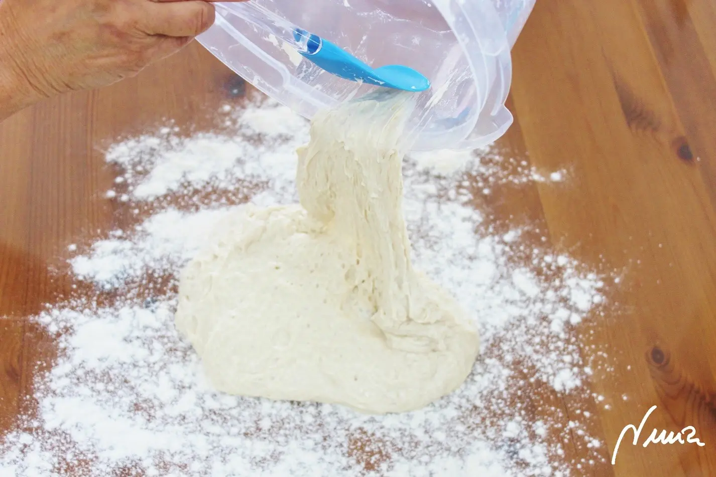 Chapata sin amasar, paso 9: Volcar la masa sobre la harina, rebañando bien el taper con una espátula de silicona.