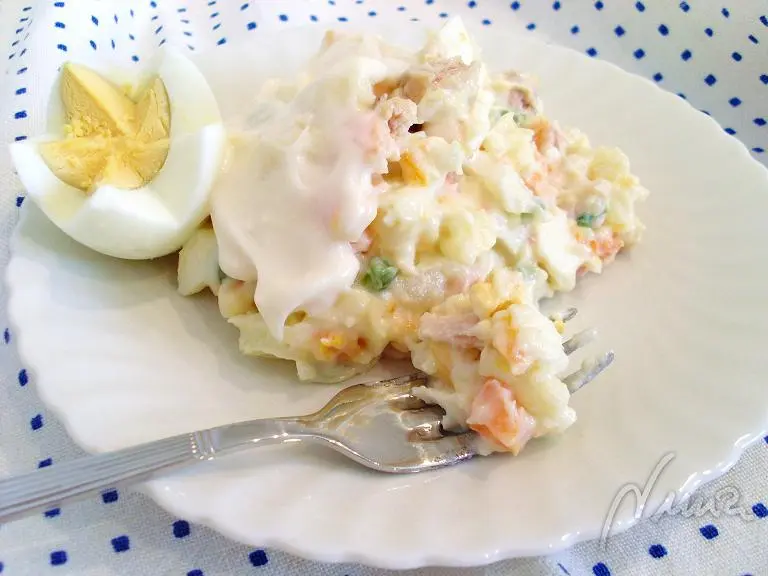 Ensaladilla de atun, paso 7: echar parte de la mayonesa en la mezcla de patata, zanahoria, etc., y remover con cuidado.
